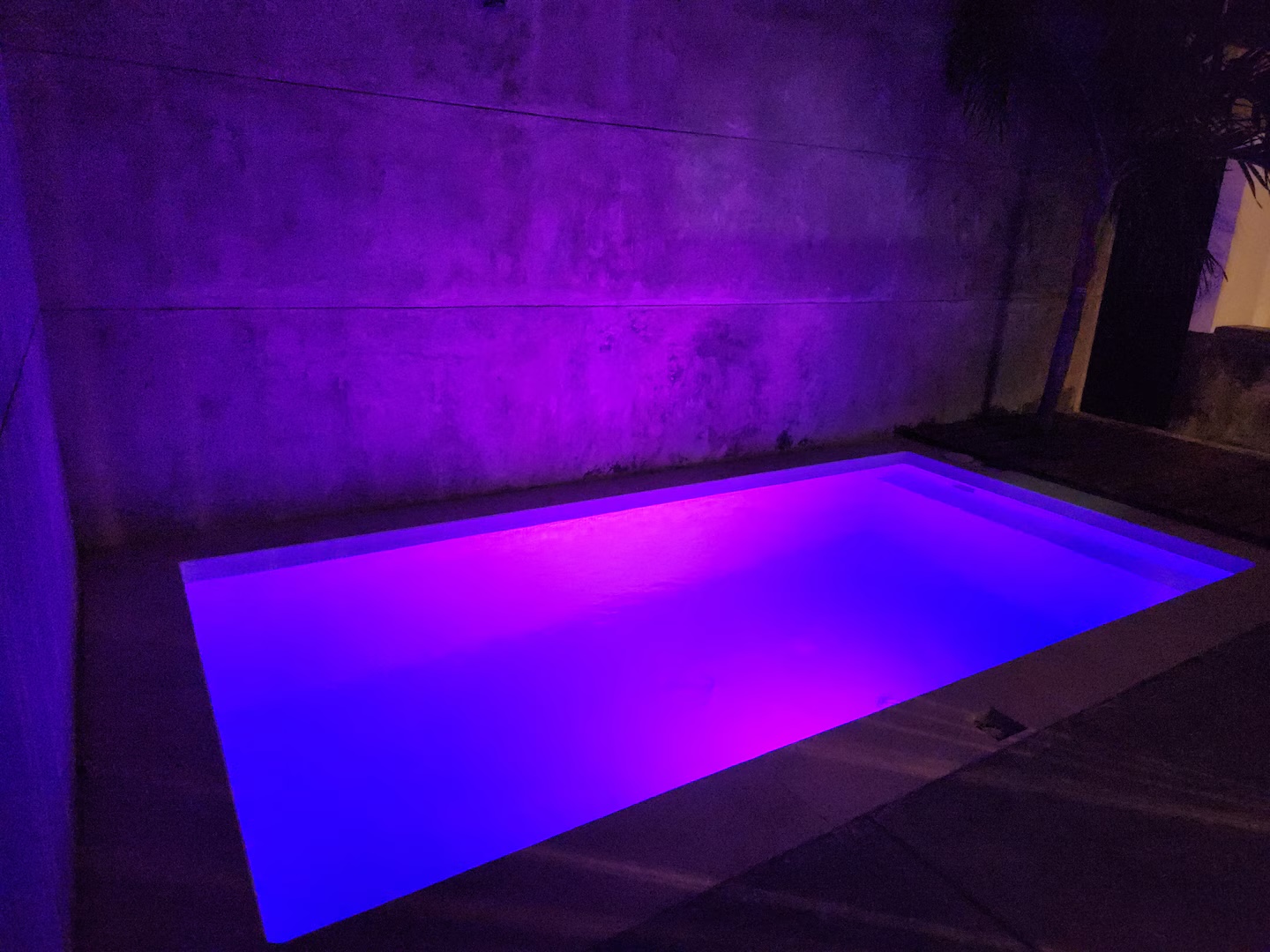 Alberca privada iluminada con luces LED de color por la noche