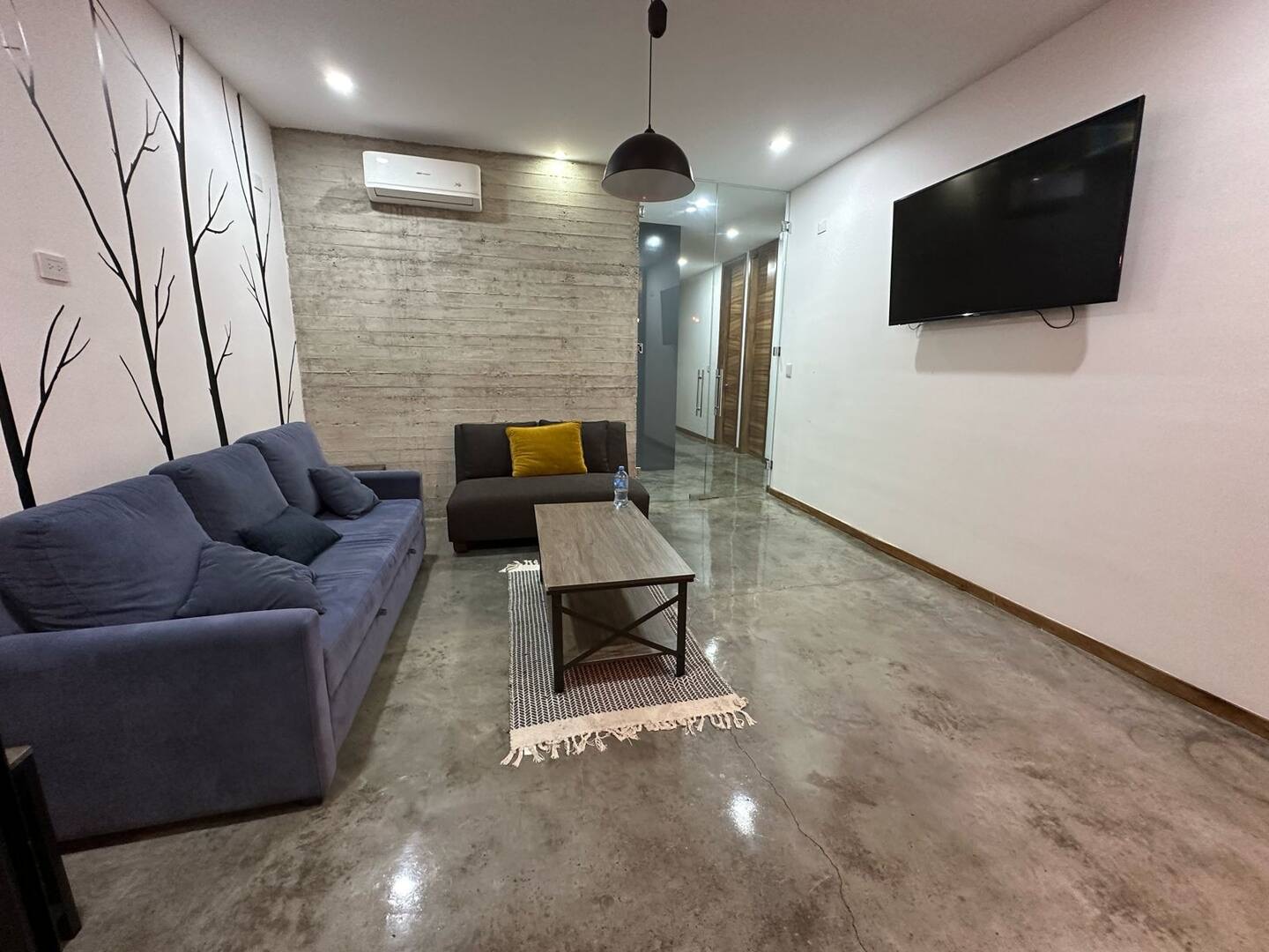Sala de estar minimalista con sofá y TV