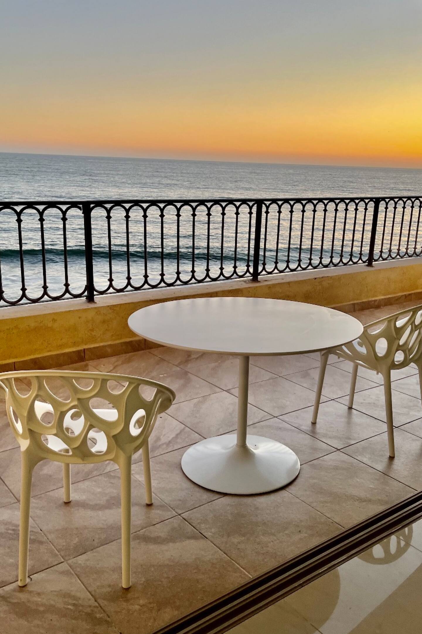 Terraza privada con mesa y sillas al atardecer