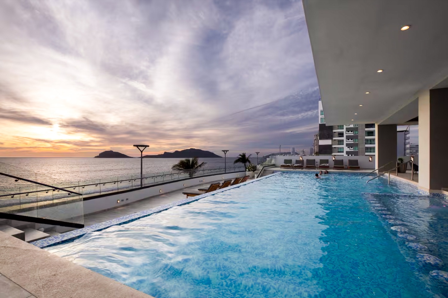 Alberca infinity con vista al mar al atardecer